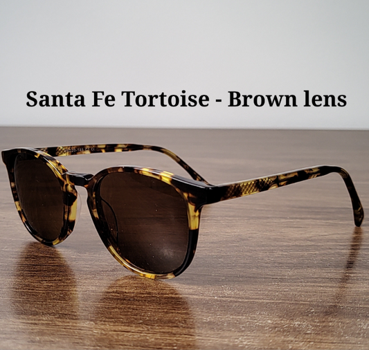 Sunglasses with tortoiseshell frame and brown lenses on a wooden surface
